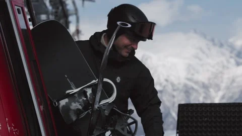 Skiers and snowboarders exit a cable car cabin, ready to hit the slopes with Stock Footage 304502125