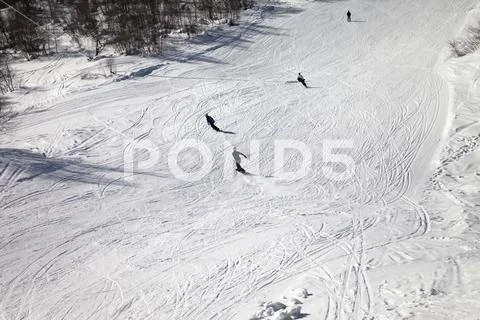 Skiers and snowboarders on ski slope at sun winter day Stock Photos