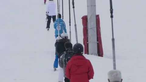 Skiers climb next to the ski using a steel telesky Stock Footage 71757725
