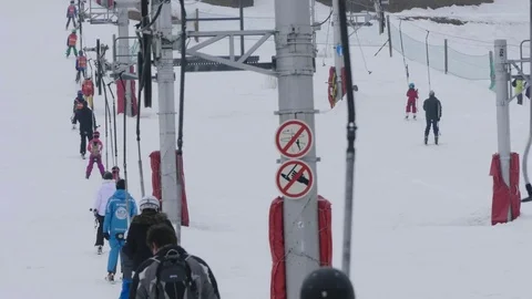 Skiers climb next to the ski, using a steel telesky Stock Footage 78220724