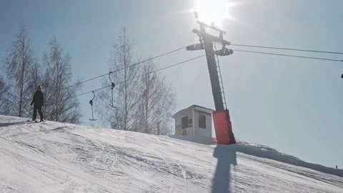 Skiers go down the ski slope. Sunny day on the slope. Ski lift on ski resort Stock-Footage 221581738