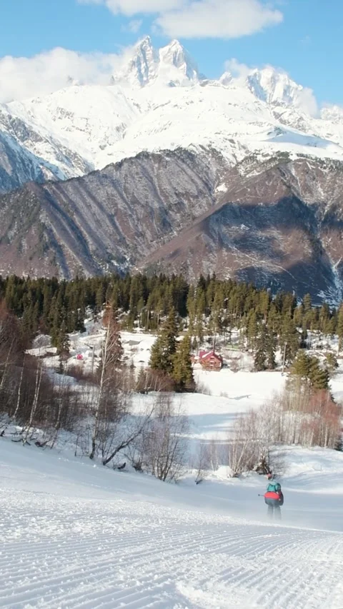 Skiers groups skiing sliding down groomed snowy mountain slope with forest .. Vídeos de archivo 311815083