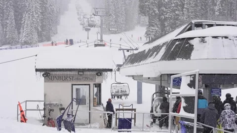 Skiers Queue Amid Heavy Snowfall at Mountain's Peak, BC, Canada, Jan 2023 Stock Footage 253121842