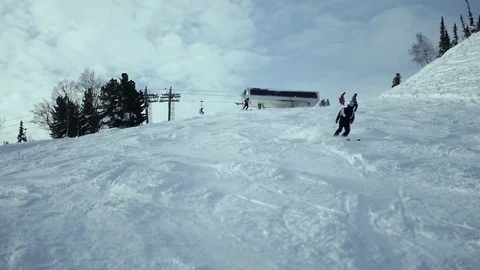 Skiers s rolls down, the slope along the road between the trees. Russia Stock Footage 70918270