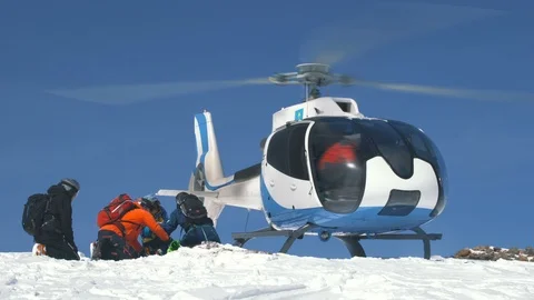 Skiers sitting waiting for loading on the helicopter Video stock 88600913
