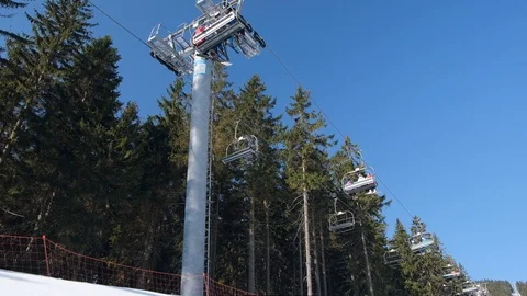 Skiers on ski elevator winter sunny day in the mountains Stock Footage 104847599