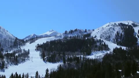 Skiers skiing down hills at a ski resort Stock Footage