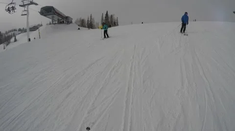 Skiers skiing fast down a mountain resort hill Stock Footage 58477225