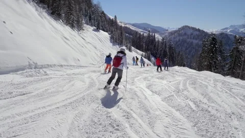 Skiers skillfully carving down maintained mountain pistes Video stock 334749522