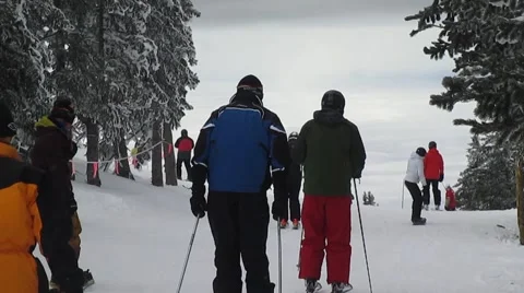 Skiers start down mountain Stock Footage 58653572