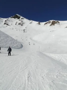 Skiers take the piste down to a ski resort .. Stock Photos