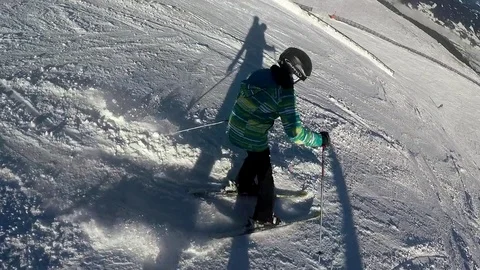 Skiiers in action skiing downhill in front of snowboarder Video stock 85377330