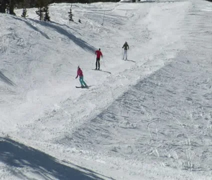 Skiiers glide down path on blue sky day Video stock 21672135