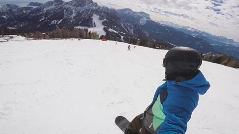 Skiing in the Alps in the winter. A man is rolling on a snowboard on the snow Stock Footage 73440960