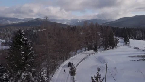 Skiing men pulled by a Jeep Wrangler on a country road up in Transylvania Stock Footage 262476670