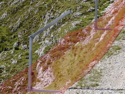Skiing slopes orange nets in summer season before snow skiing Stock Photos