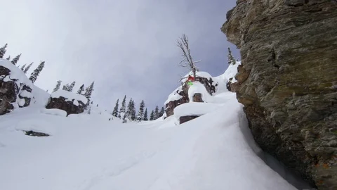 Skilful skier performing trick while jumping from high snowy mountain rock Stock Footage 116785411