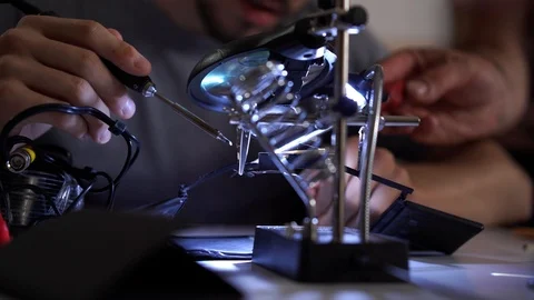 Skill apprentice working with soldering iron at his working place. Unrecognized Stock Footage 113692560