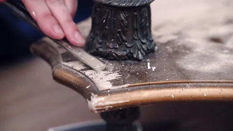 Skill carpenter rubbing wood surface with metal chisel to remove old paint Stock Footage 236938620