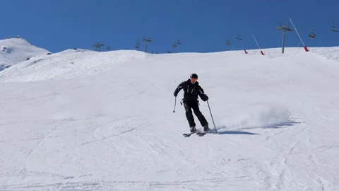 Skill skier carving down snowy mountain slope Stock Footage 323442398