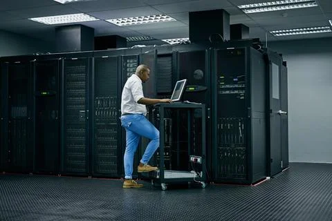 Skilled in all things IT. an IT technician using a computer while working in a Stock Photos