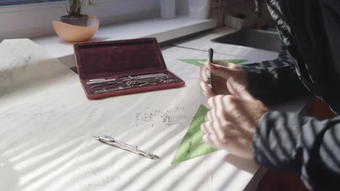 Skilled Architect Drawing Blueprint Concept Plan in Sunlit Design Studio Stock Footage 341926536