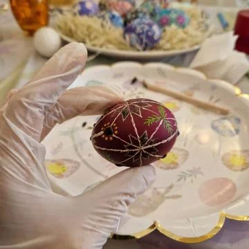 Skilled artisan carefully decorates an Easter egg using the traditional Ukrai Stock Photos