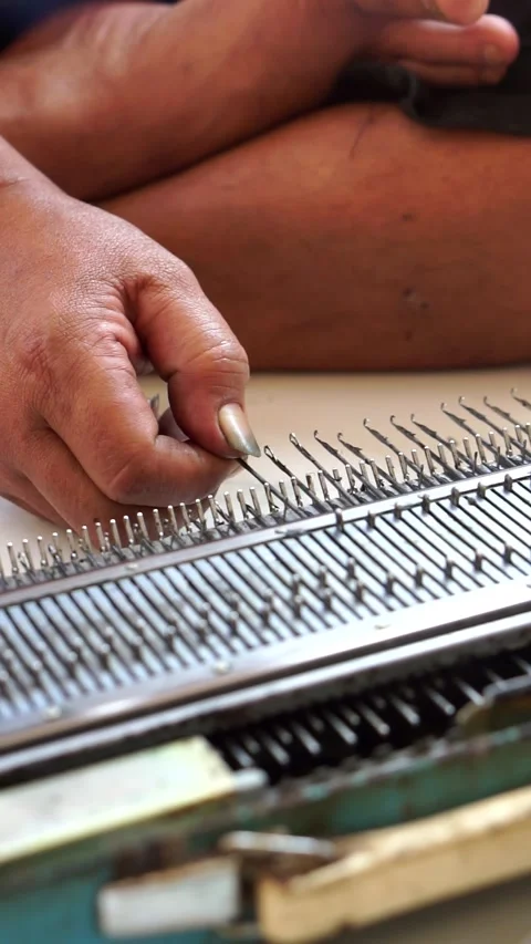 A skilled artisan utilizes a traditional hand knitting machine Видео 338054562