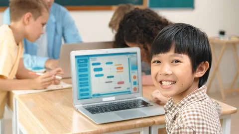 Skilled asian boy coding program and looking at camera in STEM class. Pedagogy. Foto stock