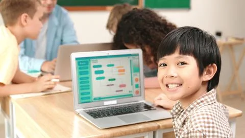 Skilled asian boy coding program and looking at camera in STEM class. Pedagogy. Stock Photos