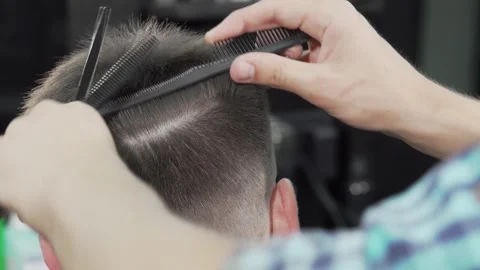 Skilled barber expertly styling a man's hair with precision Stock Footage 311984230