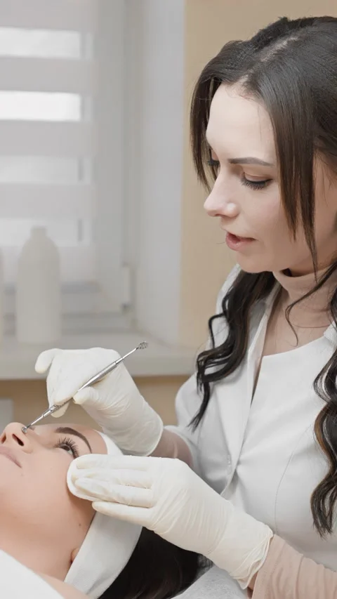 A skilled beauty specialist is precisely applying eyelash extensions in a modern Stock Footage 277908413