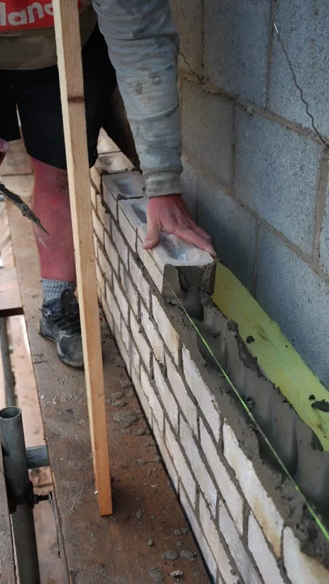 Skilled Bricklayer Constructing Wall with Precision and Care Stock Footage 327427999