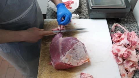 Skilled butcher cuts beef meat in a slaughterhouse, top view Stock Footage 89829351