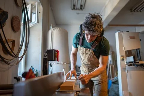 Skilled carpenter apply full attention to precision work on jointer machine Stock Photos