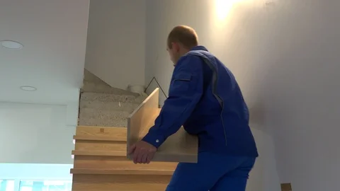 Skilled carpenter man install oak stairs in new apartment Stock Footage 111189889
