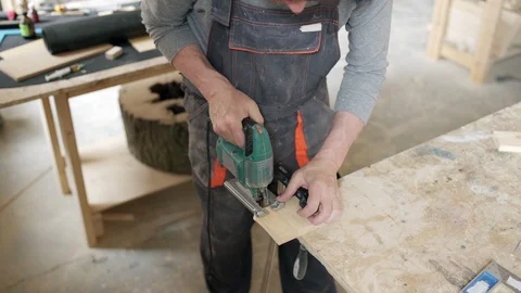 Skilled carpenter using speed jig saw to cut wood Stock Footage 104624343