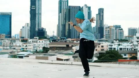Skilled caucasian B-boy dancer practicing street dancing at rooftop. Endeavor. Stock Photos