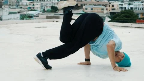 Skilled caucasian B-boy dancer practicing street dancing at rooftop. Endeavor. 写真素材