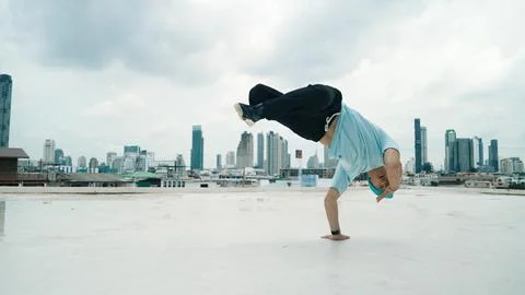 Skilled caucasian B-boy dancer practicing street dancing at rooftop. Endeavor. 写真素材
