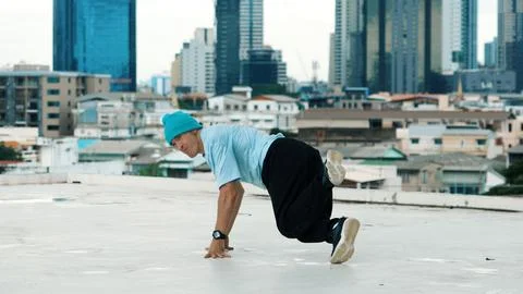 Skilled caucasian B-boy dancer practicing street dancing at rooftop. Endeavor. Stock Photos