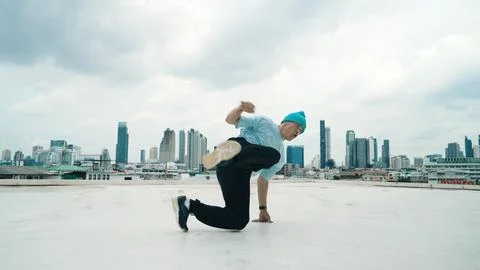 Skilled caucasian B-boy dancer practicing street dancing at rooftop. Hiphop. Stock Photos
