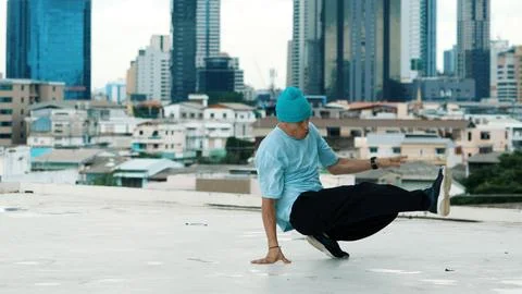Skilled caucasian B-boy dancer practicing street dancing at rooftop. Hiphop. Stock Photos