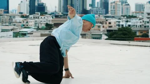 Skilled caucasian B-boy dancer practicing street dancing at rooftop. Hiphop. Stock Photos