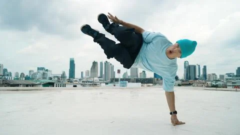 Skilled caucasian B-boy dancer practicing street dancing at rooftop. Hiphop. Stock Photos