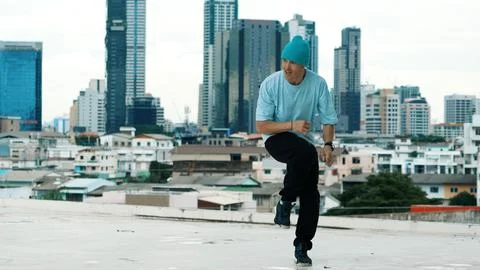 Skilled caucasian B-boy dancer practicing street dancing at rooftop. Hiphop. Stock Photos