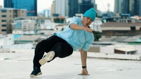 Skilled caucasian B-boy dancer practicing street dancing at rooftop. Hiphop. Stock Photos