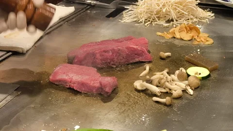 A skilled chef cooks premium Kobe steak with precise movements at the counter Video stock 323202436