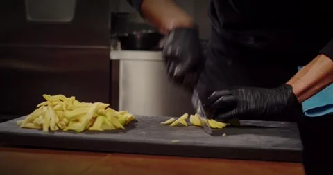 A skilled chef diligently preparing fresh vegetables in a modern, sophisticated Stock Footage 297692466