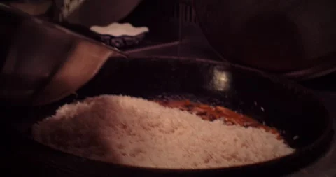 A skilled chef is meticulously preparing rice in a bustling, professional Stock Footage 297694517